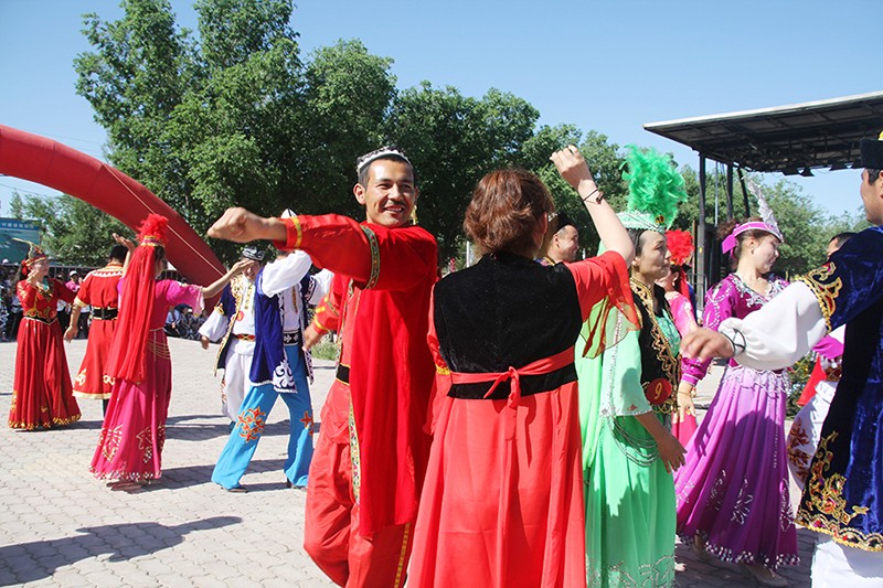 乌苏市甘河子镇杨家庄子村民族团结一条街上，村民们伴着音乐共同跳起欢快的舞蹈.jpg