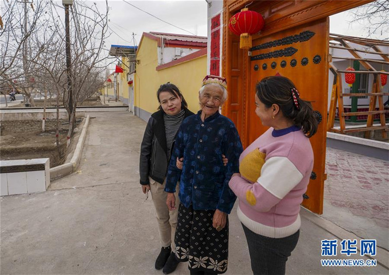 在和田地区于田县先拜巴扎镇良种场村，库尔班·吐鲁木的女儿托乎提汗·库尔班（中）与家人一道在院门口散步（2019年2月13日摄）。新华社记者 赵戈 摄.jpg