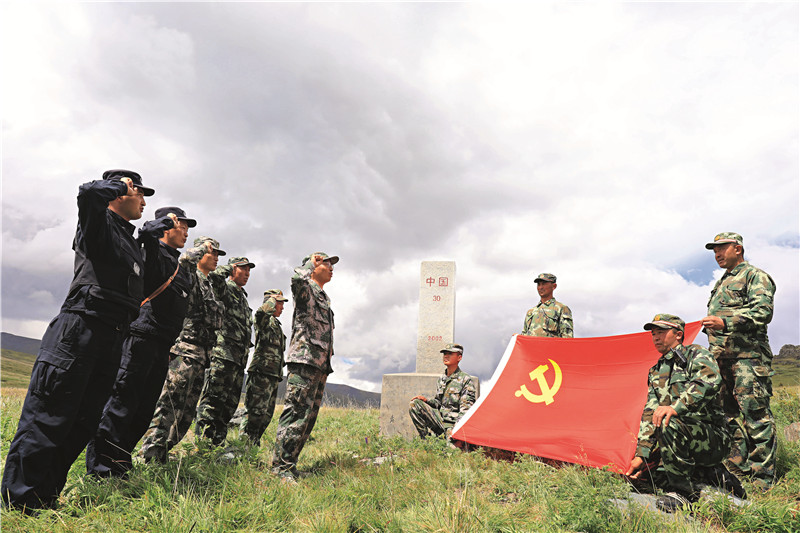 新疆阿勒泰地区富蕴县民警、护边员与巡边哨所官兵党员在界碑前开展重温入党誓词活动.jpg