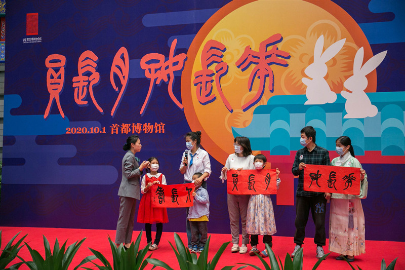 首博文化援疆。首都博物馆和田地区图书馆通过视频联线方式，在北京、和田同时主办庆祝中华人民共和国成立71周年暨两地各民族家庭共话中秋团圆活动，北京分会场开展的“花长好 月长圆 人长寿”石鼓文书法作品临摹活动。摄影：罗征.jpg